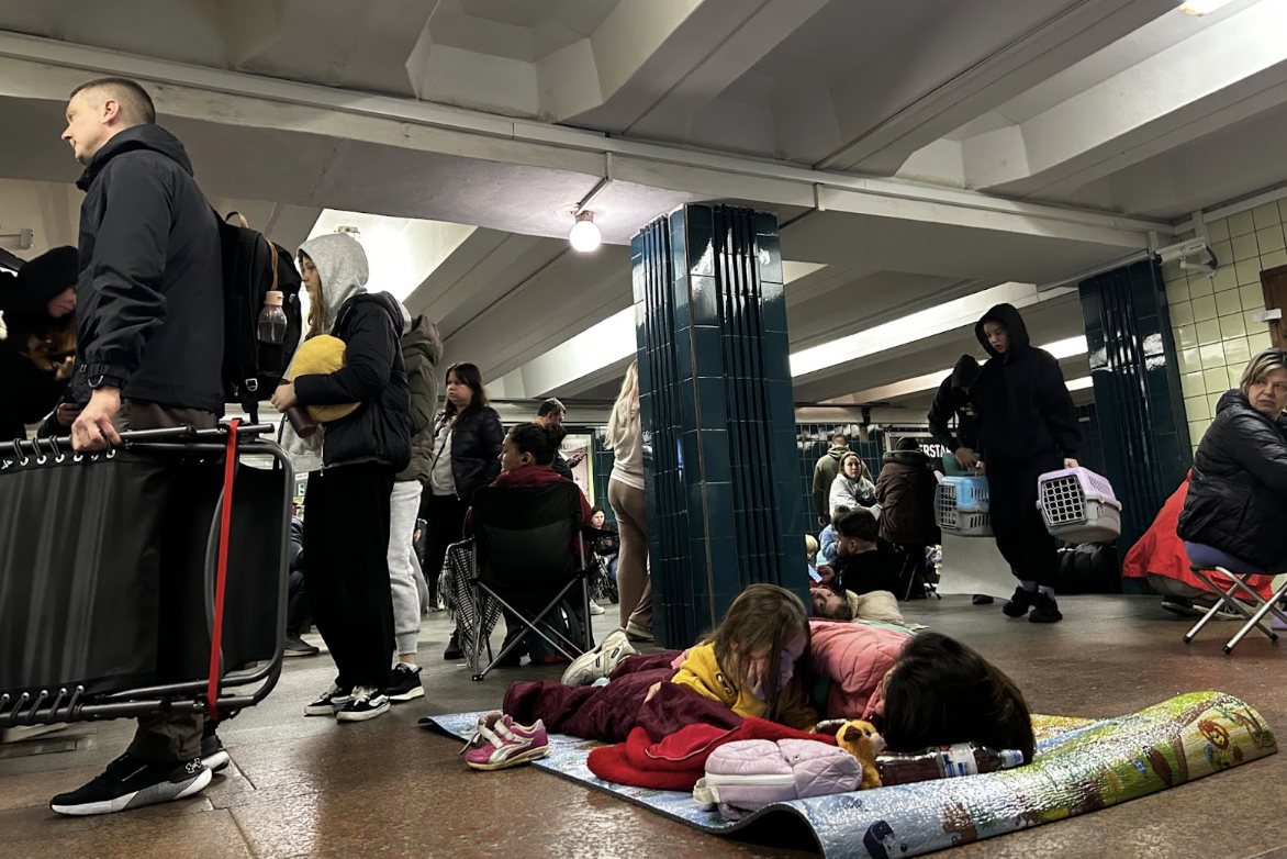 Residents arriving at the metro station while others try to rest. (Photograph by Joseph Roche)